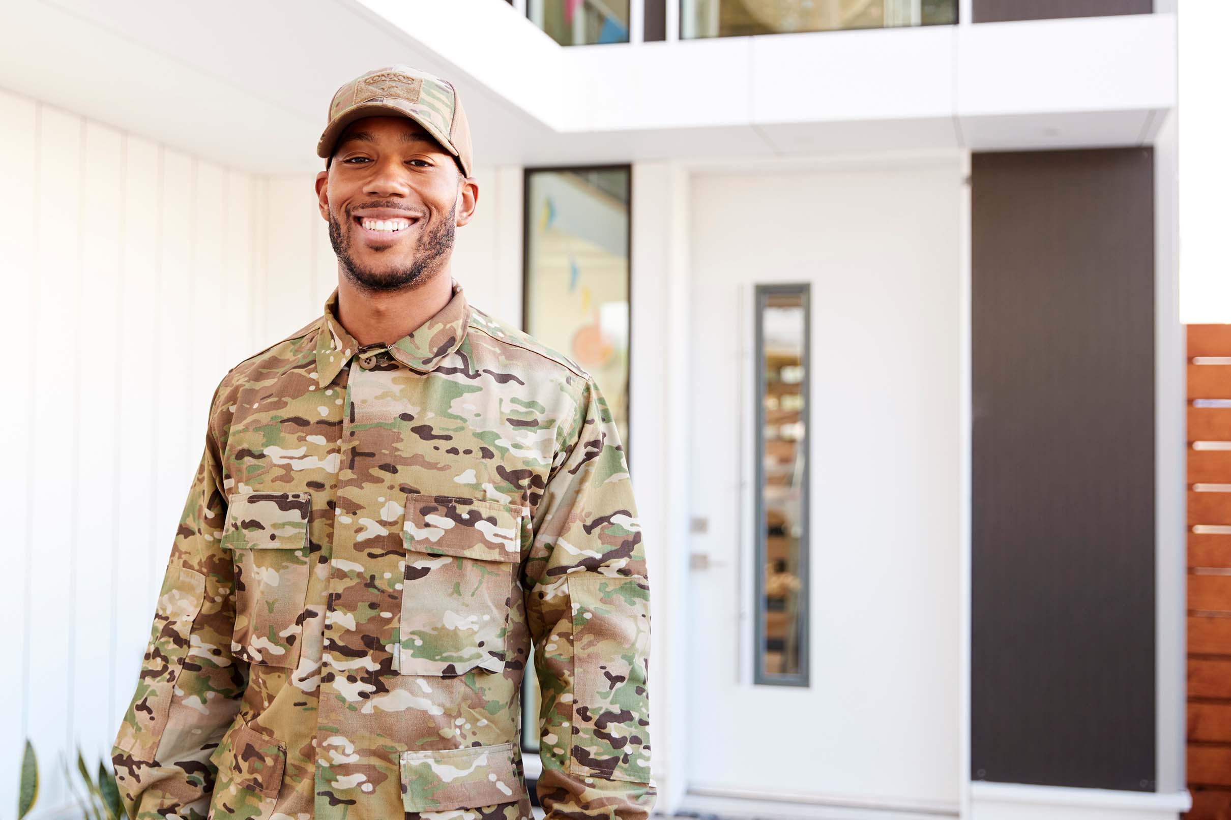 Service member outside a home with a new Prime Roofing roof